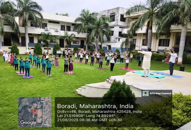 Students performing yoga on the campus lawn on International Yoga Day
